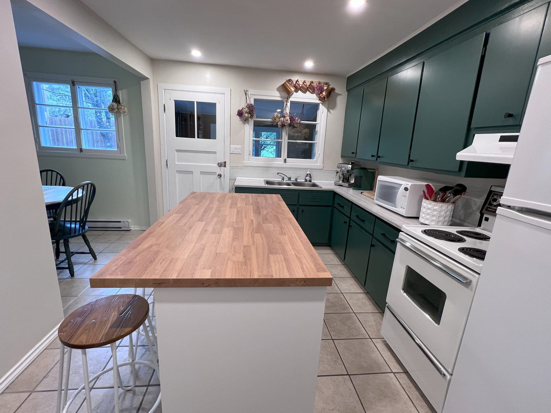 Kitchen with green cabinets and island